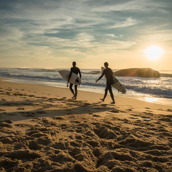 Sprachaufenthalt Frankreich, Surfer am Strand bei Sonnenuntergang