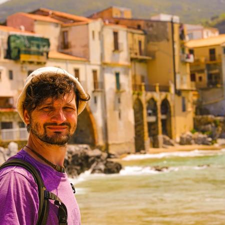 Sprachaufenthalt Italien, Taormina, Mann vor Altstadt von Cefalu