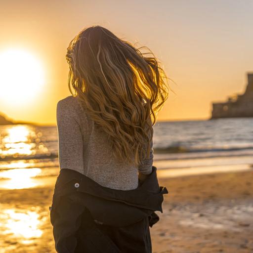 Sprachaufenthalt Frau am Meer mit Sonnenuntergang