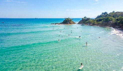 Sprachaufenthalt Australien, Byron Bay, Surfer im Meer, Küste