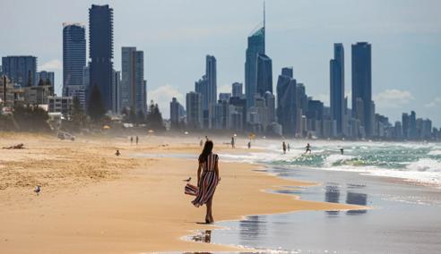 Sprachaufenthalt Australien, Gold Coast, Frau am Strand vor Skyline