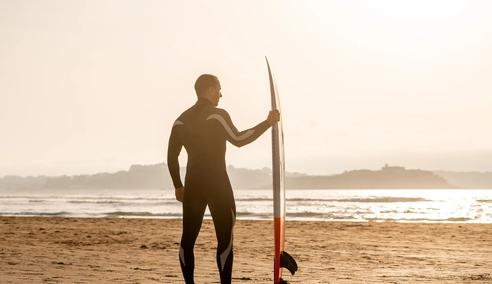 Sprachaufenthalt Spanien, Surfer am Strand bei Sonnenuntergang